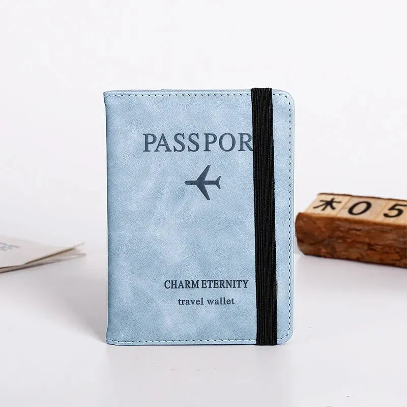 Light blue passport cover with a black strap and text indicating charm eternity travel wallet