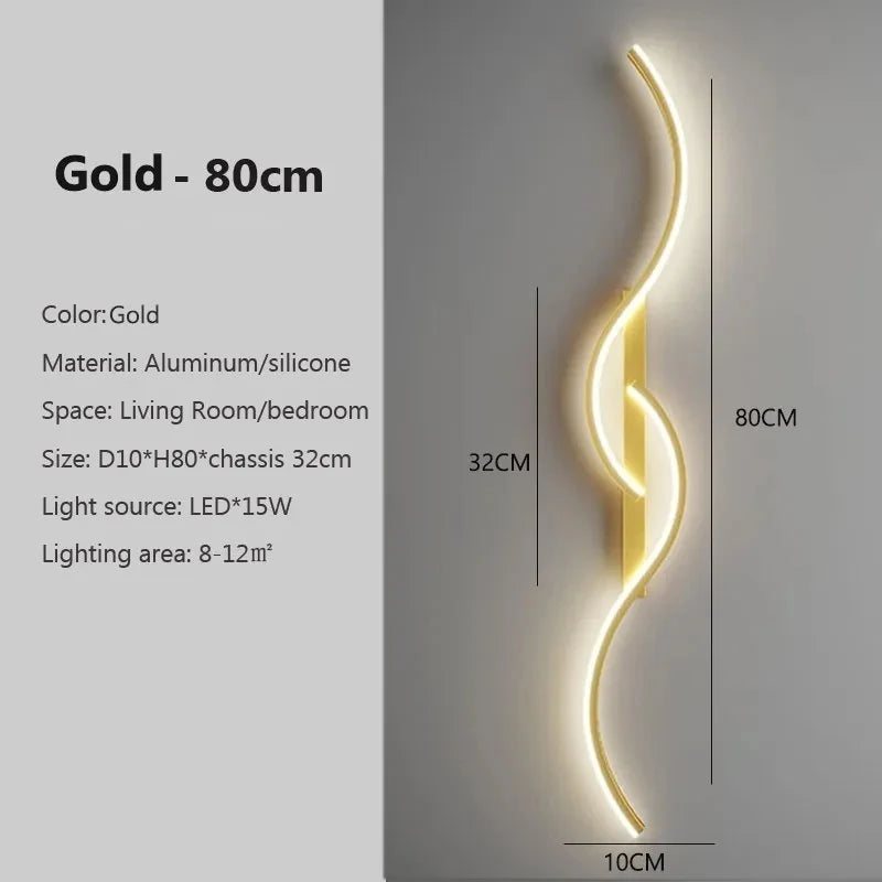 A vertical gold LED wall lamp with a curved design mounted on a wall.