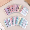 A set of clear plastic envelopes containing cash savings challenge slips in pink, purple, and blue colors.