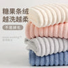 A stack of fluffy microfiber towels in various pastel colors, including pink, cream, gray, and blue.