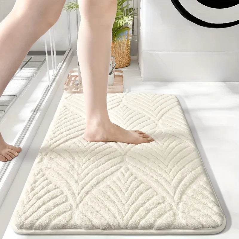 A beige plush velvet bathroom mat with a diamond pattern is shown on a white floor.