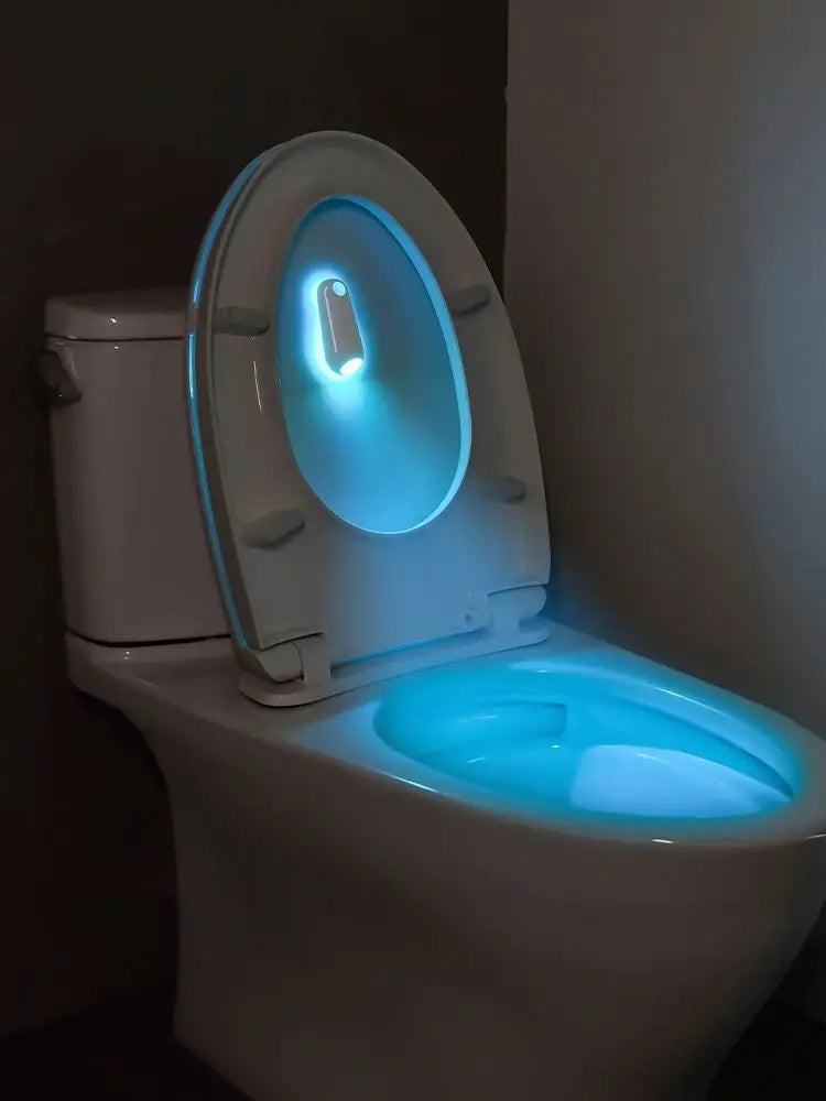 A white toilet featuring a motion-activated night light with a blue glow inside the seat.