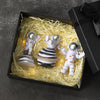 A set of three handcrafted astronaut figurine resin spaceman desk decor items displayed in a black box surrounded by straw-li