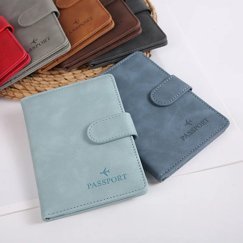 Collection de porte-passeport en cuir dans diverses nuances, rouge, marron et bleu-vert.