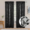 A pair of black vintage floral lace sheer curtains hanging in a window.