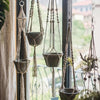 A collection of adjustable stainless steel cable hanging kits with various sized pots and frames suspended by twine.
