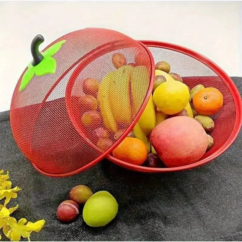 A red metal fruit basket with a mesh cover filled with various fruits like apples, lemons, and oranges.