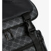A close-up of a black PU leather backpack featuring a subtle gray monogram pattern and silver zippers.