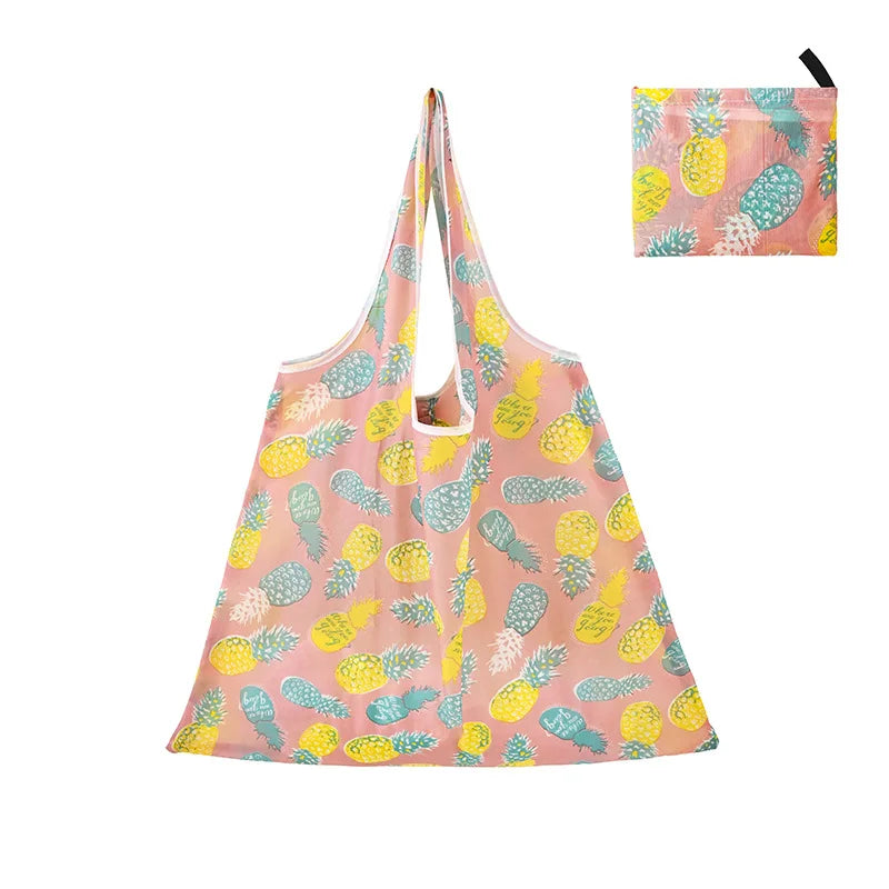 A pink reusable shopping tote bag featuring a pattern of yellow and green pineapples.