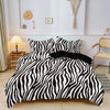 A black and white zebra print duvet cover set displayed on a bed with a wooden nightstand and wall decor.