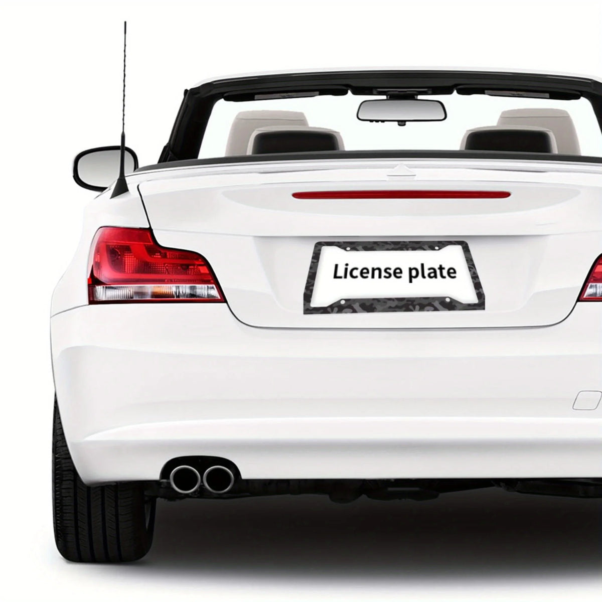 Rear view of a white car with an aluminum license plate frame and black and grey camo finish.