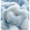 Close-up of a light blue fluffy fleece fabric with a rabbit design pattern.