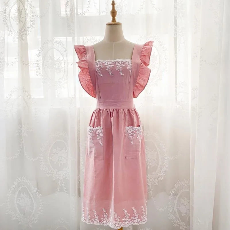 Pink ruffled cotton linen kitchen apron with lace trim displayed on a mannequin.