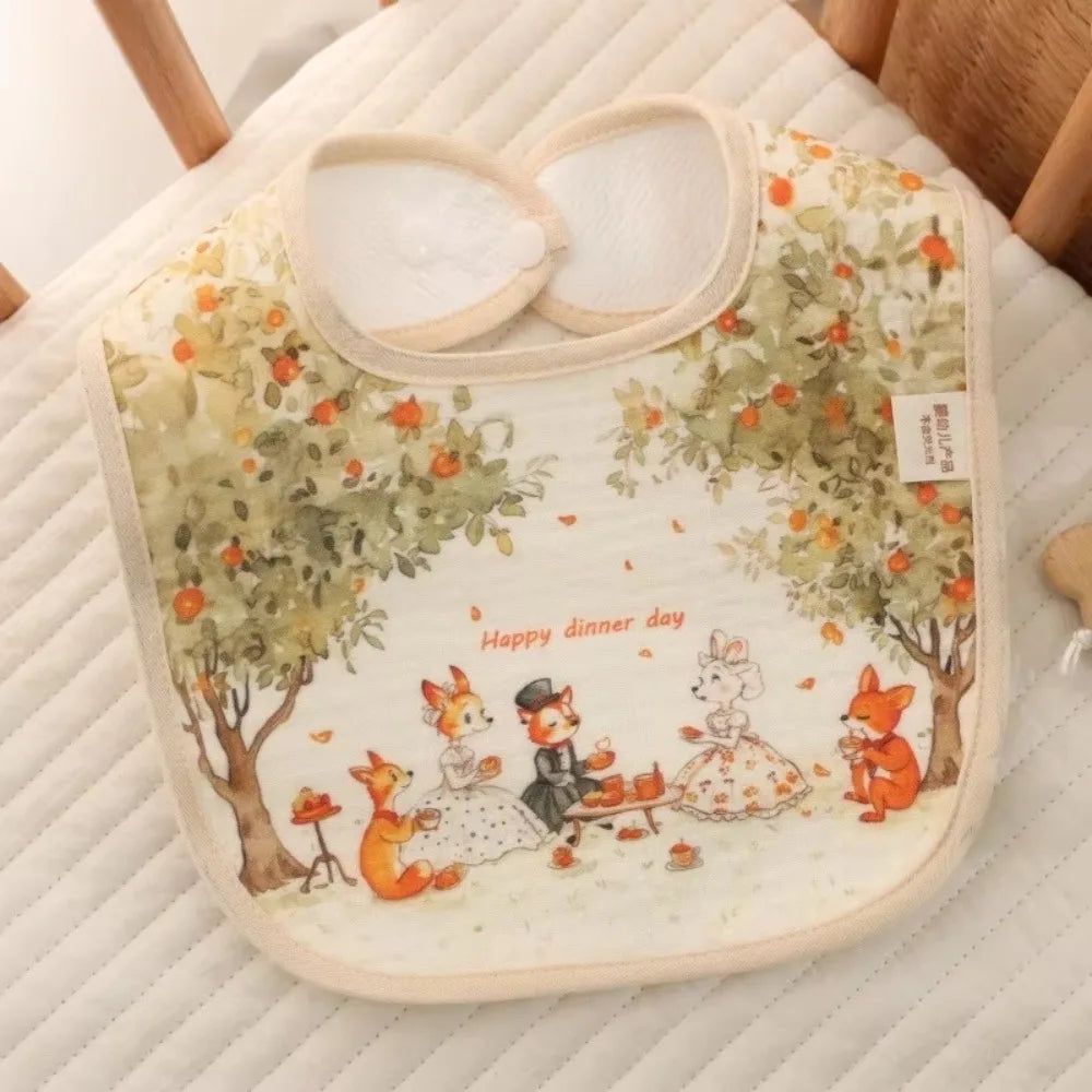 A soft cotton waterproof baby bib featuring an illustration of woodland animals and fruit on a light background.