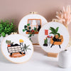 A set of embroidery hoops featuring pre-printed floral and cat designs on white fabric.