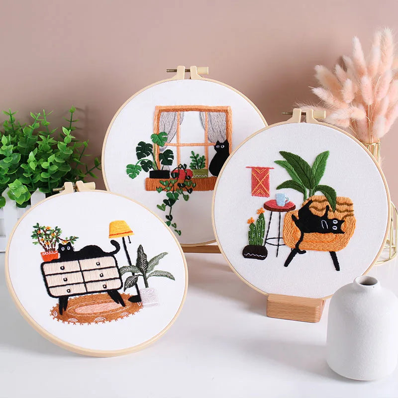 A set of embroidery hoops featuring pre-printed floral and cat designs on white fabric.