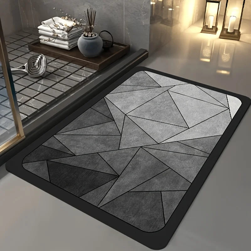 A geometric gray bathroom mat with a black border placed on a modern bathroom floor.