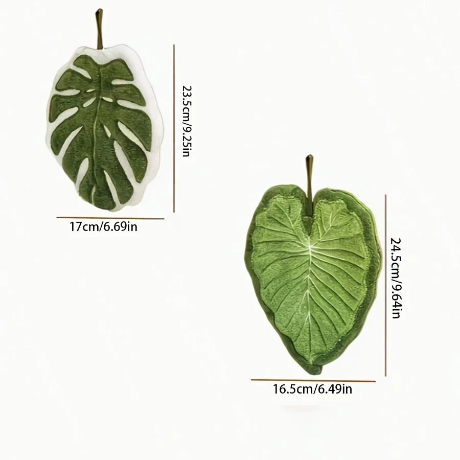 A green, leaf-shaped coral fleece hand towel with a hanging loop, shown in profile.