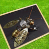 A durable metal insect puzzle decor featuring a detailed, metallic-toned insect model displayed in a wooden frame on green gr