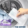 A hand is placing a white dryer sheet into the drum of a washing machine for use in a tumble dryer.