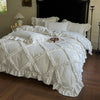 A white ruffled duvet cover set with matching pillowcases displayed on a bed in a room.