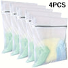 Four fine mesh laundry bags for delicates in various shades of white and mint green.