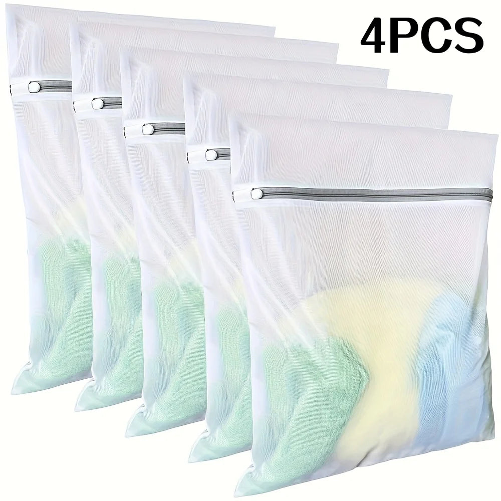 Four fine mesh laundry bags for delicates in various shades of white and mint green.