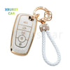 A white TPU car key fob cover case with a gold-colored chain and keyring.