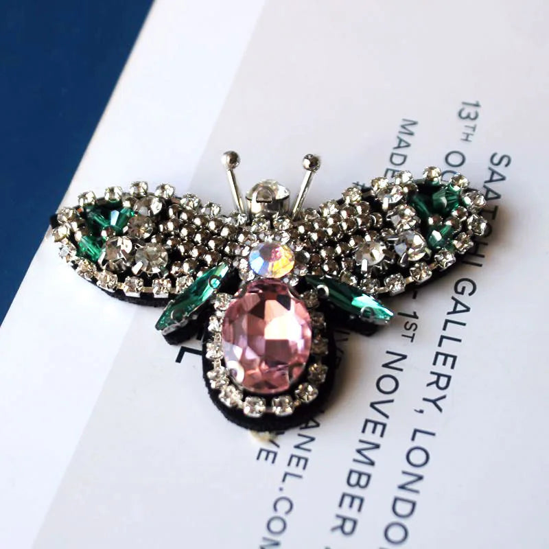 Handcrafted rhinestone bee sew-on patch featuring sparkling wings and a pink gemstone center