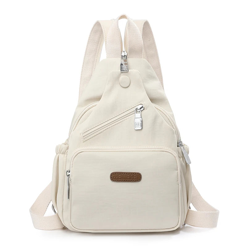 A beige waterproof nylon crossbody sling bag with adjustable straps and a flap closure.