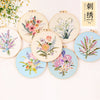 A collection of round embroidery kits featuring floral designs in various colors and styles.