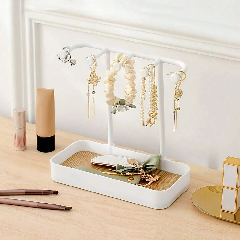 Elegant jewelry display rack with a white frame, wooden base, and various necklaces and earrings.