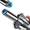 Close-up view of a heavy-duty grease gun coupler with a bright blue light visible at the tip.