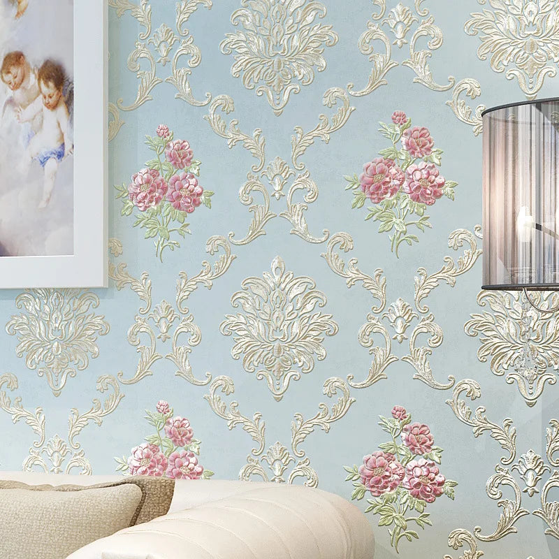 Light blue floral wallpaper featuring ornate gold scrollwork and pink flowers on a wall.