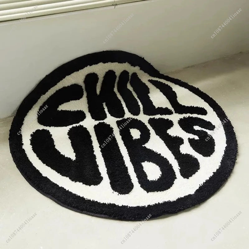 A round black and white letter carpet with the text SKILL VIBES embroidered in black.