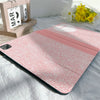 Pink composition notebook iPad case with a pencil holder lying on a white sheet.