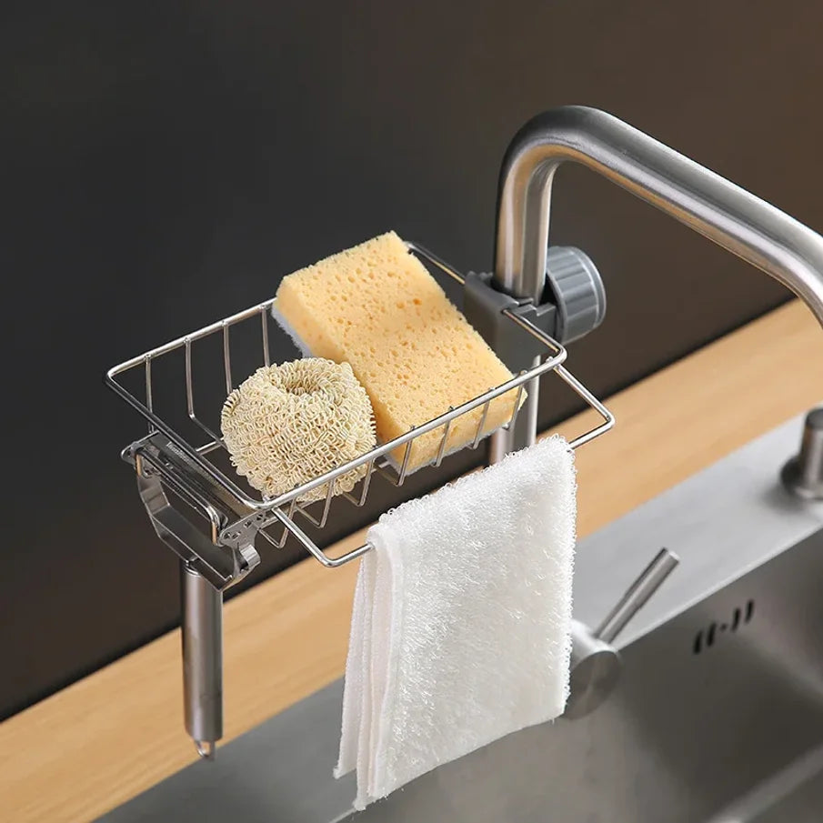 Stainless steel sink hanging drain rack holding a yellow sponge and a white towel