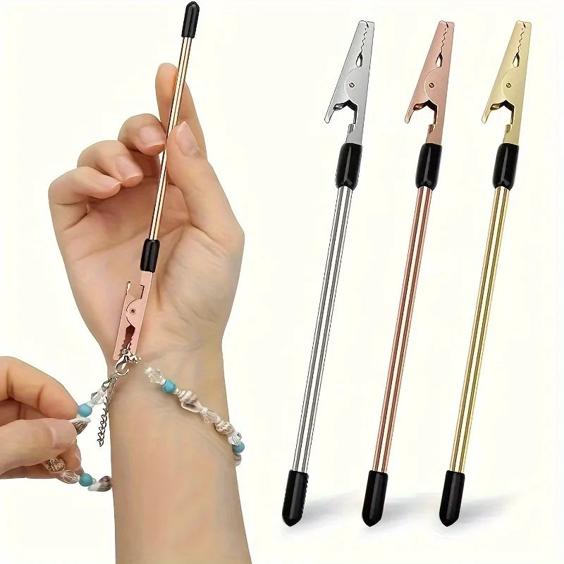 A hand holds a retractable bracelet fastening tool with various metal finishes and a chain.