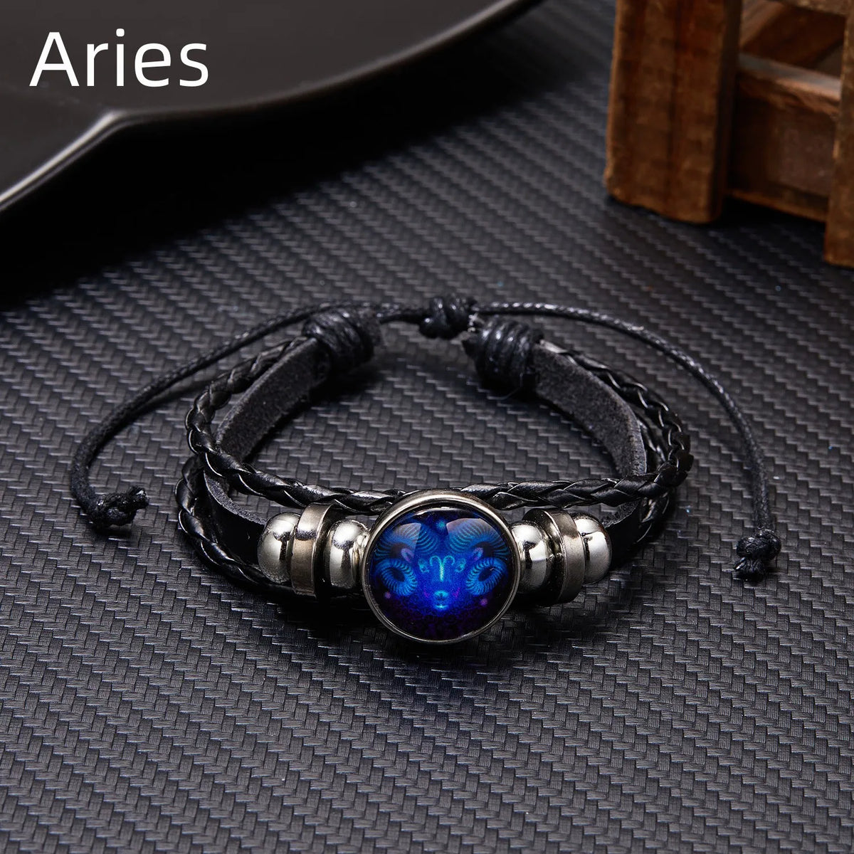 A black leather wrap bracelet featuring a blue gemstone charm and silver accents.