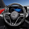Close-up of a black carbon fiber texture steering wheel cover for a Mercedes-Benz interior.