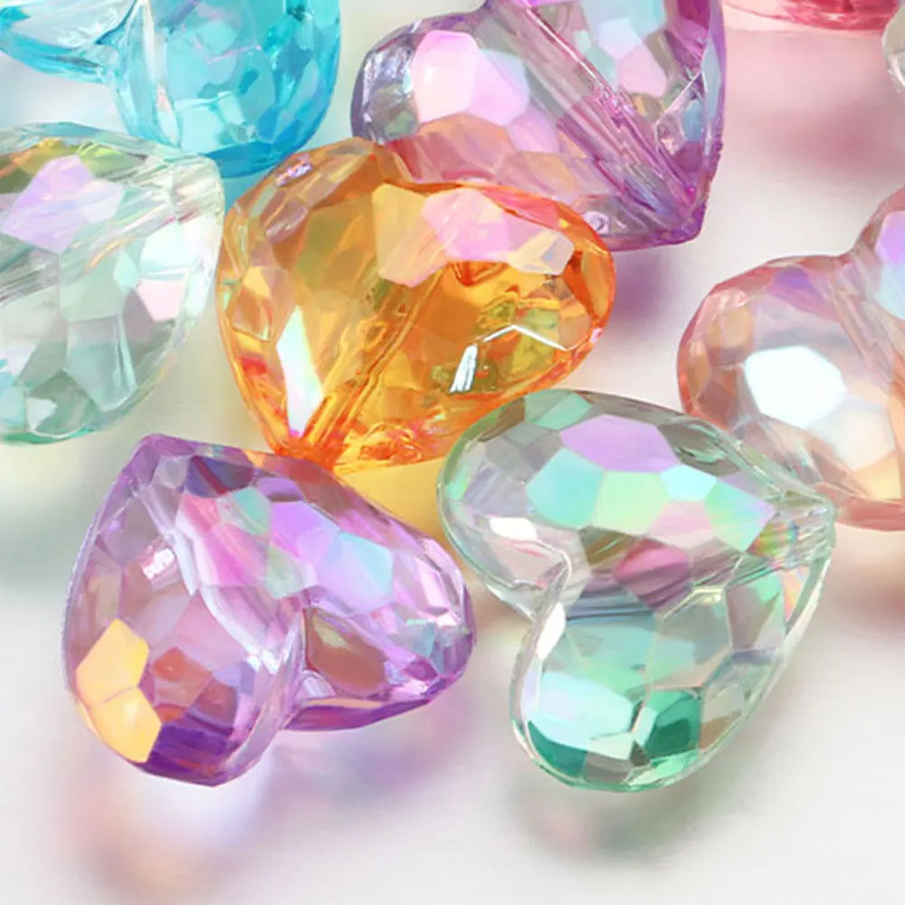 A collection of 20 iridescent acrylic heart-shaped beads in various shades of pink, purple, and green.