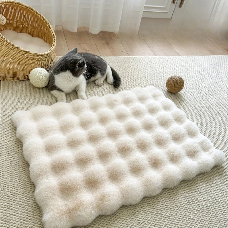 Ein beiger Plüsch-Tiermatten ist auf einem hellen Teppich mit einer Katze und einem Hund in der Nähe platziert.
