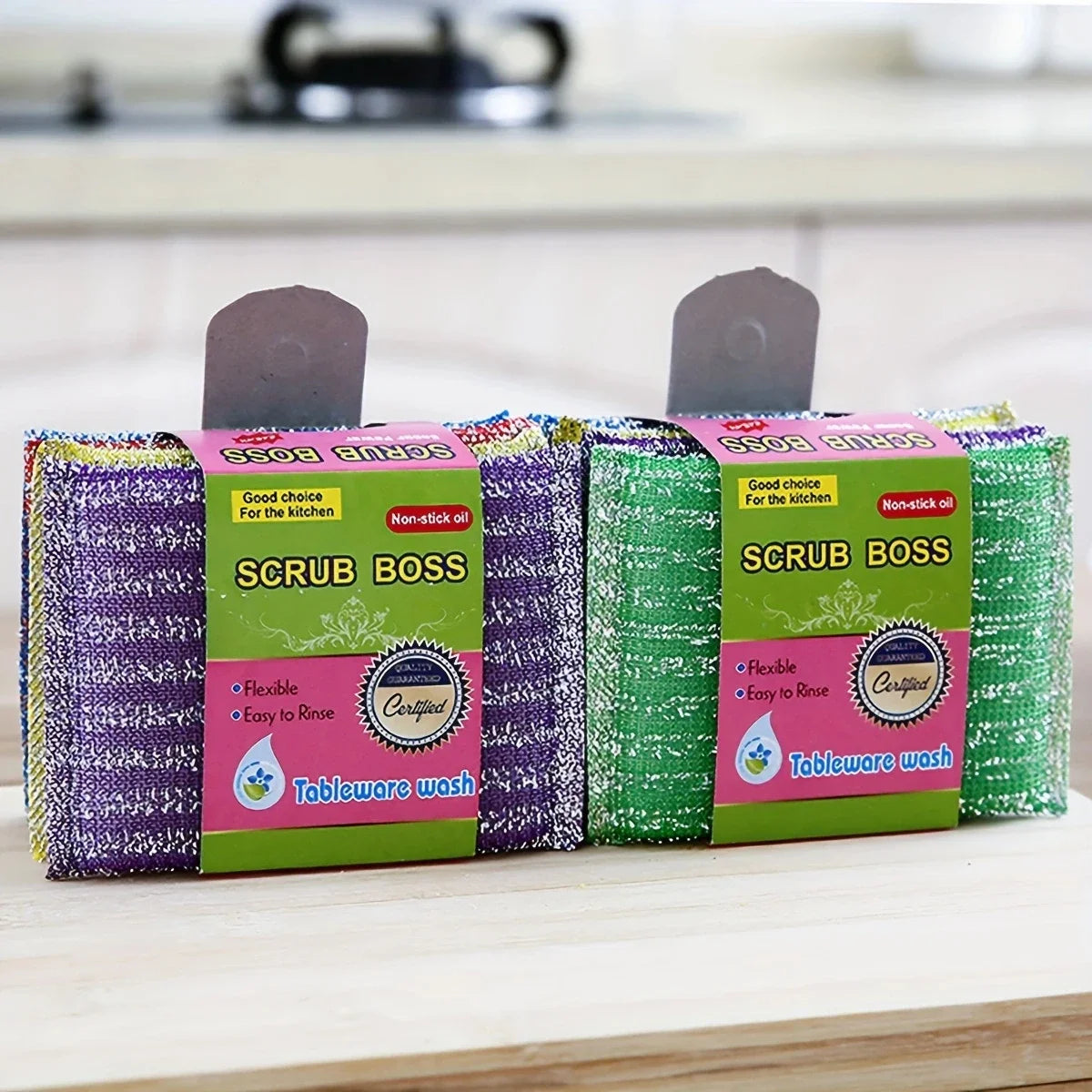 A pack of four green and purple Scrub Boss non-stick kitchen scouring sponges.