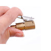 A hand holds a brass tire inflator quick-connect adapter with a clip-on lock mechanism.