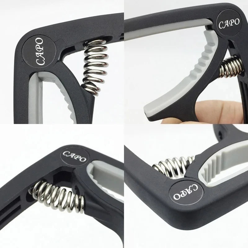 Close-up view of a black adjustable guitar capo with a silver spring mechanism and bridge pin puller.