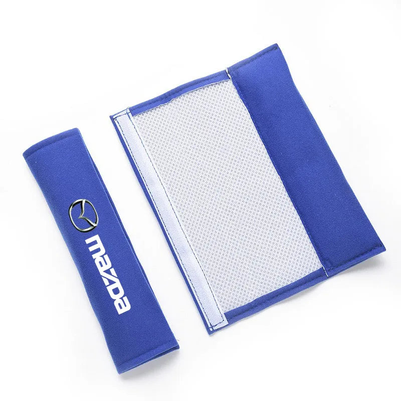 A blue soft cotton car seat belt shoulder protector cover with a silver Mazda logo.