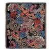 A dark woven blanket featuring a floral pattern in shades of pink, orange, and blue.