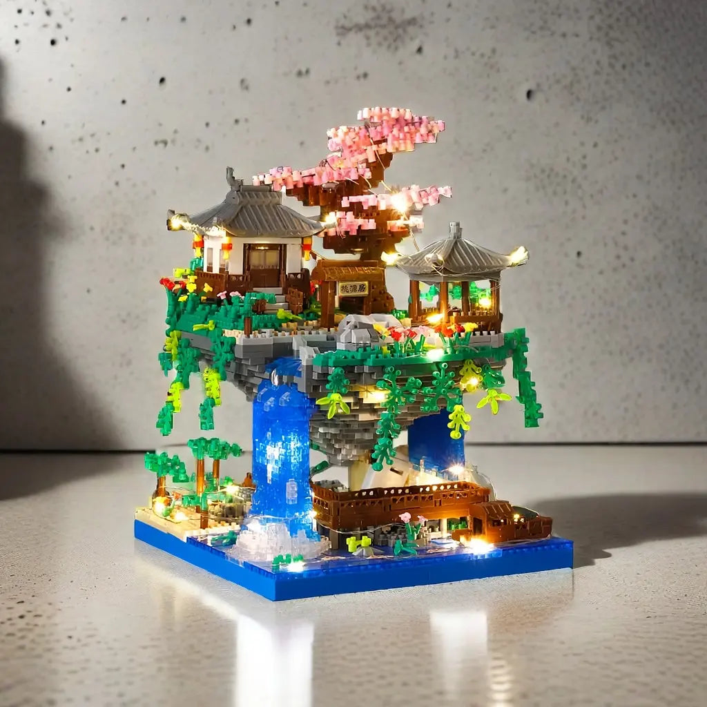 A miniature diorama of a pagoda treehouse featuring pink blossoms and glowing lights built with micro building blocks.