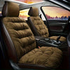 A plush brown car seat cover with a padded backrest shown inside a vehicle cabin.