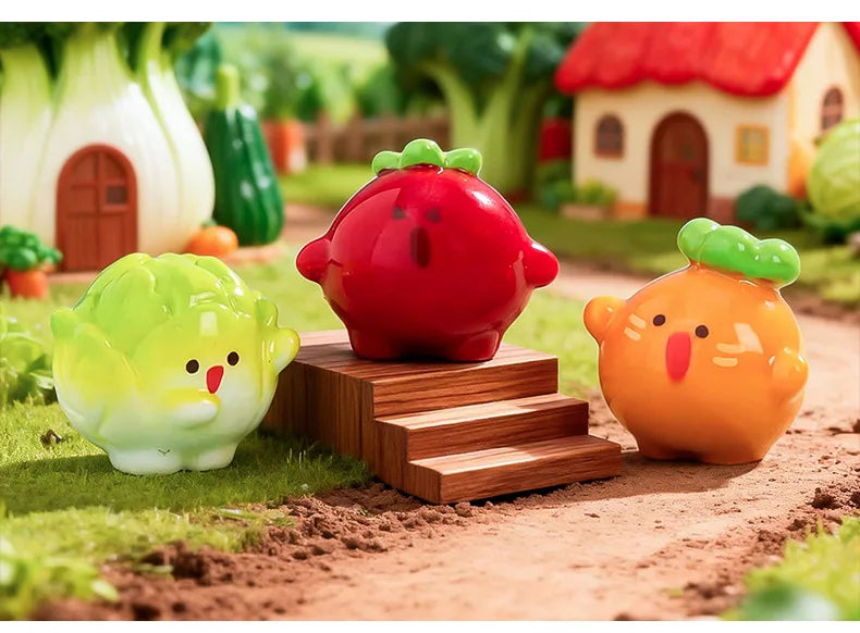 A set of hand-painted resin vegetable figurines, including a red tomato, yellow squash, and green lettuce, displayed in a gar